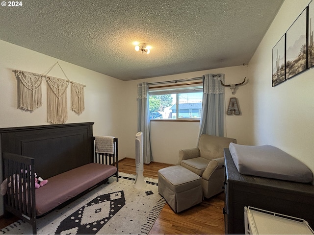 bedroom featuring a textured ceiling and hardwood / wood-style floors