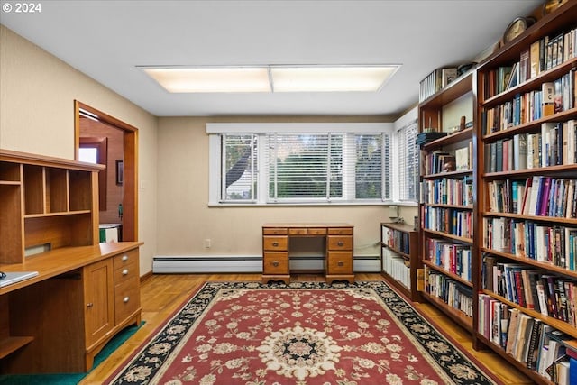 office area featuring light hardwood / wood-style flooring, built in desk, and a baseboard radiator