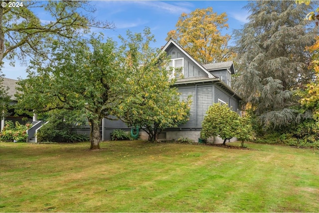 view of side of home with a yard