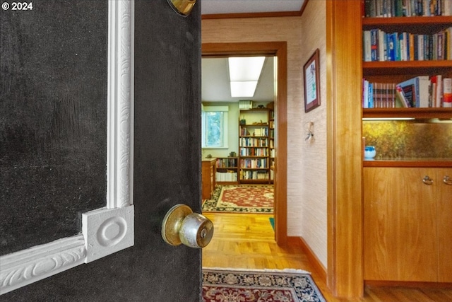 hallway with crown molding and wood-type flooring