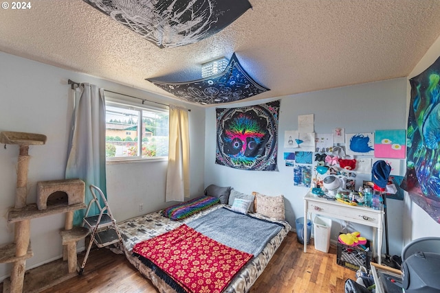 bedroom with wood-type flooring and a textured ceiling