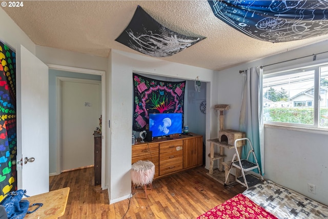 bedroom featuring a textured ceiling and dark hardwood / wood-style flooring