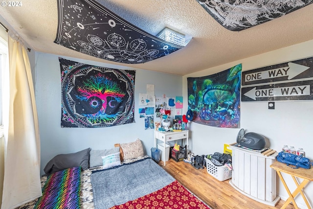 bedroom with wood-type flooring and a textured ceiling