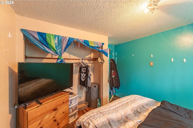 bedroom featuring a textured ceiling and wood-type flooring