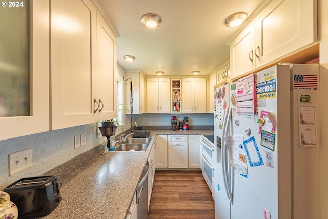 kitchen featuring white appliances, white cabinetry, dark stone counters, sink, and dark hardwood / wood-style floors