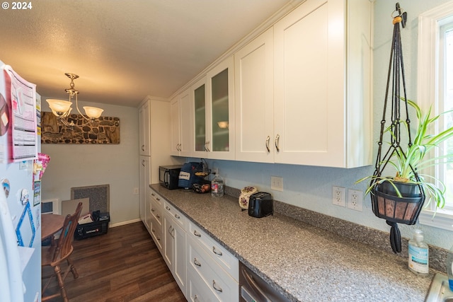 kitchen featuring dark wood-type flooring, white cabinetry, light stone counters, and a notable chandelier