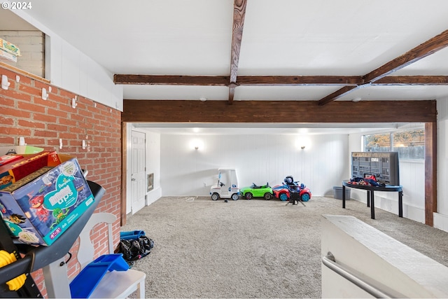 game room with beamed ceiling, carpet floors, and brick wall