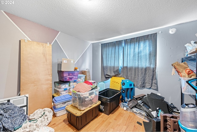 rec room with hardwood / wood-style floors and a textured ceiling