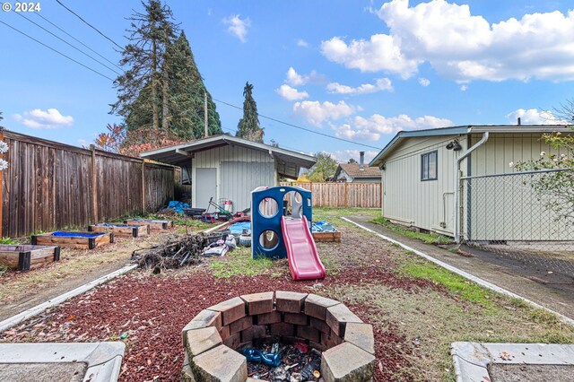 2051 N Park Ave, Eugene, OR 97404 - fenced backyard featuring a fire pit, a shed, and an outdoor structure