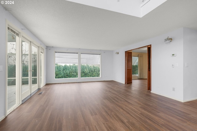 empty room with dark hardwood / wood-style flooring and a textured ceiling