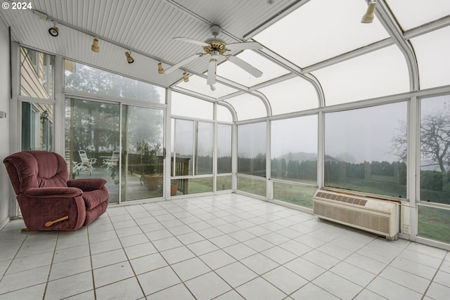 unfurnished sunroom featuring a wall unit AC, a wealth of natural light, and ceiling fan