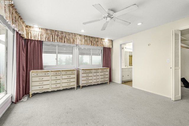 unfurnished bedroom featuring light carpet, ceiling fan, and ensuite bathroom