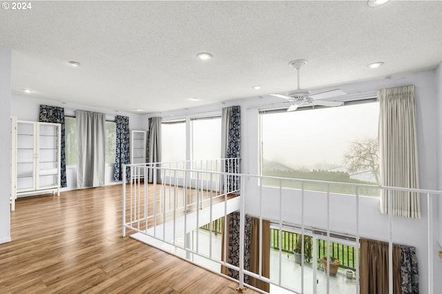 spare room with plenty of natural light, hardwood / wood-style floors, and a textured ceiling