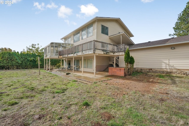 rear view of house featuring a patio area, a sunroom, a yard, and a wooden deck