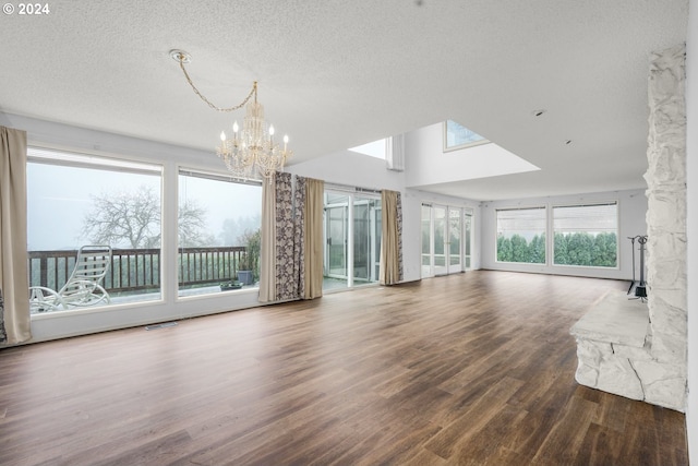 unfurnished living room with hardwood / wood-style floors, a textured ceiling, and a notable chandelier