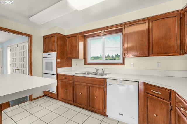 kitchen featuring dishwasher, light tile patterned flooring, and sink