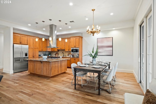 kitchen featuring a center island, island range hood, decorative light fixtures, and built in appliances