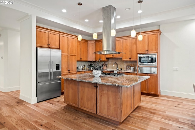 kitchen with an island with sink, stone counters, appliances with stainless steel finishes, and hanging light fixtures