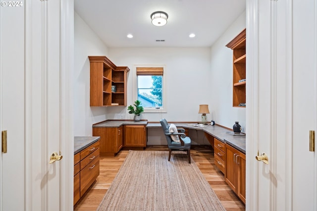 office space featuring light wood-type flooring, visible vents, built in desk, and recessed lighting