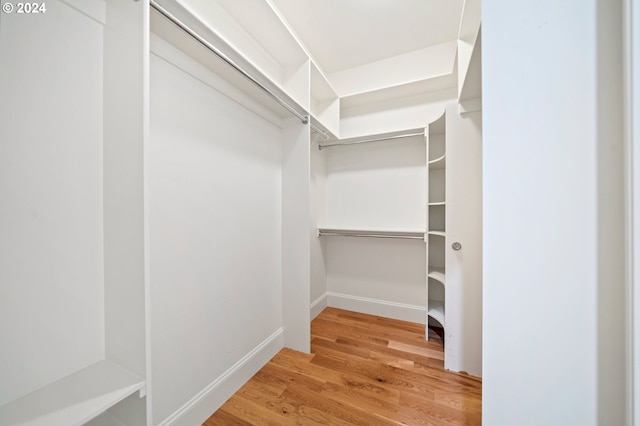 walk in closet with wood finished floors