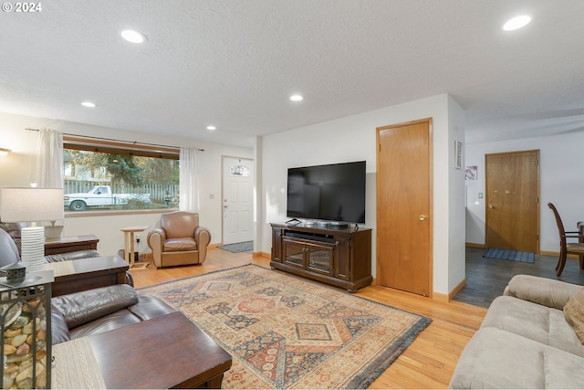 living room featuring a textured ceiling and light wood-type flooring