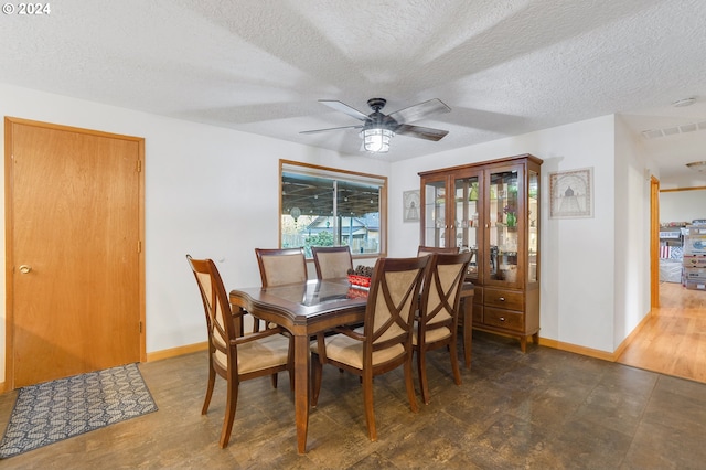 dining area with ceiling fan, dark hardwood / wood-style floors, and a textured ceiling