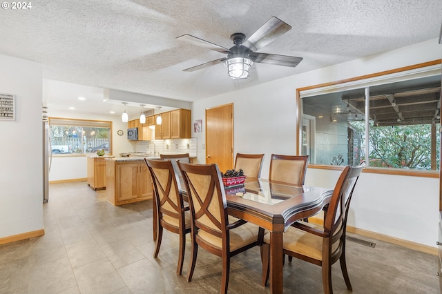 dining space with ceiling fan, light tile patterned floors, and a textured ceiling