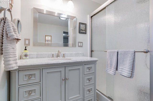 bathroom with a shower with door and vanity