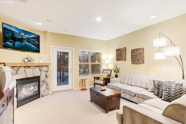 living room featuring a stone fireplace and carpet