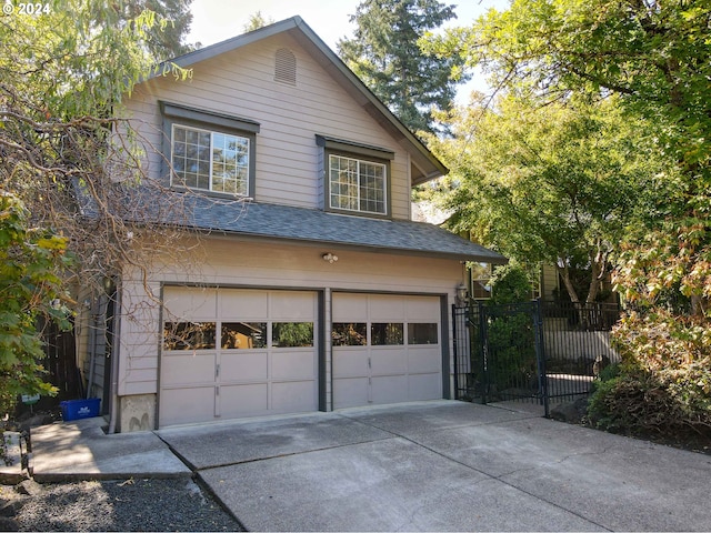 view of side of property featuring a garage, fence, concrete driveway, and roof with shingles