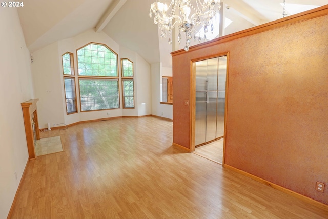 empty room with light hardwood / wood-style floors, elevator, beam ceiling, an inviting chandelier, and high vaulted ceiling