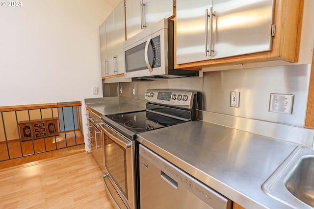 3794 Wilshire Ln, Eugene, OR 97405 - kitchen featuring stainless steel appliances, stainless steel counters, light wood-type flooring, and a sink