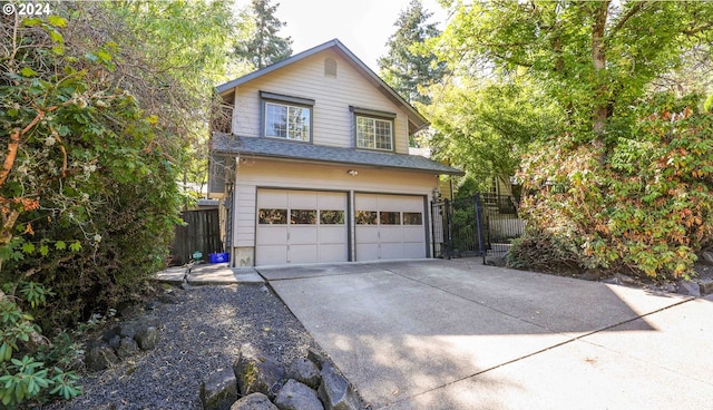 view of front of home featuring a shingled roof, fence, driveway, and an attached garage