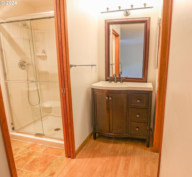 bathroom with vanity, walk in shower, and hardwood / wood-style flooring