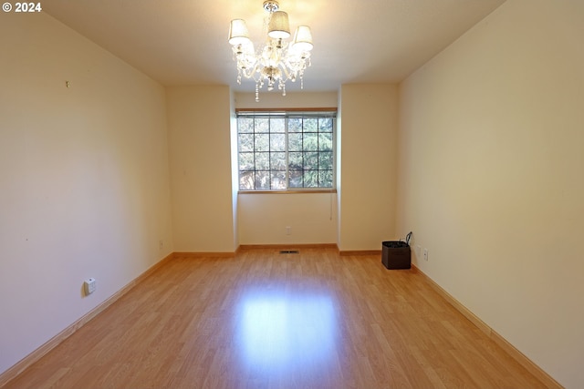 3794 Wilshire Ln, Eugene, OR 97405 - spare room featuring wood finished floors, a chandelier, and baseboards