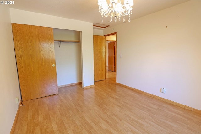 unfurnished bedroom featuring a closet, a notable chandelier, and light hardwood / wood-style flooring