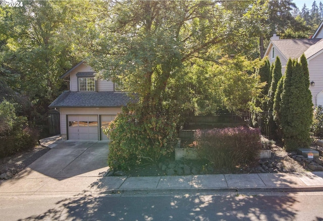 3794 Wilshire Ln, Eugene, OR 97405 - obstructed view of property with an attached garage, concrete driveway, roof with shingles, and fence