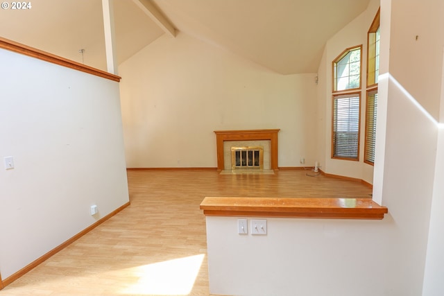 3794 Wilshire Ln, Eugene, OR 97405 - unfurnished living room featuring wood finished floors, beamed ceiling, high vaulted ceiling, baseboards, and a fireplace with flush hearth