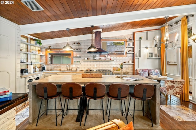 kitchen featuring wood ceiling, a breakfast bar, lofted ceiling with beams, decorative light fixtures, and light hardwood / wood-style floors