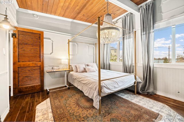 bedroom with crown molding, hardwood / wood-style floors, wooden ceiling, and an inviting chandelier