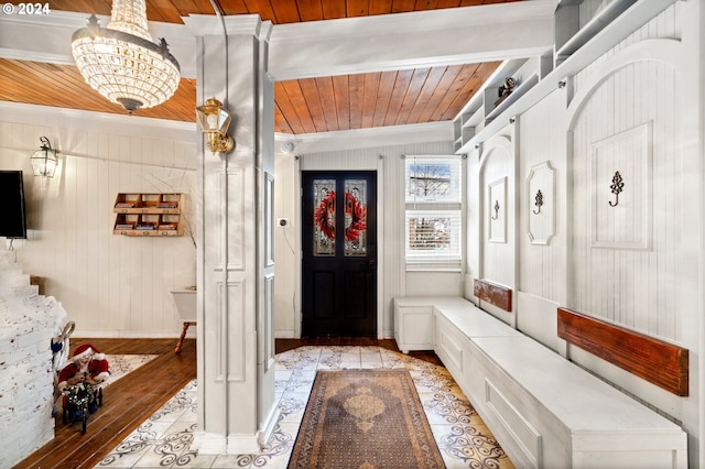 mudroom with light wood-type flooring, wooden walls, lofted ceiling with beams, wooden ceiling, and a notable chandelier