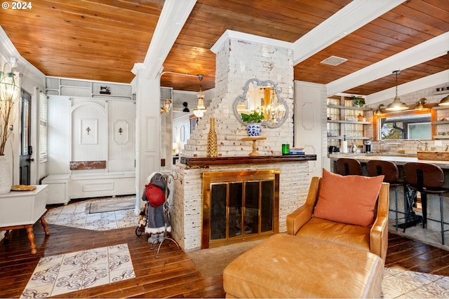 living area featuring beamed ceiling, wood-type flooring, wood ceiling, and a brick fireplace