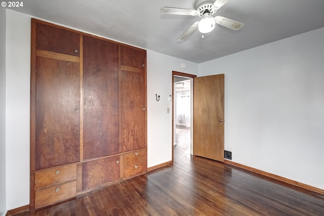 unfurnished bedroom featuring a closet, dark wood-type flooring, and ceiling fan