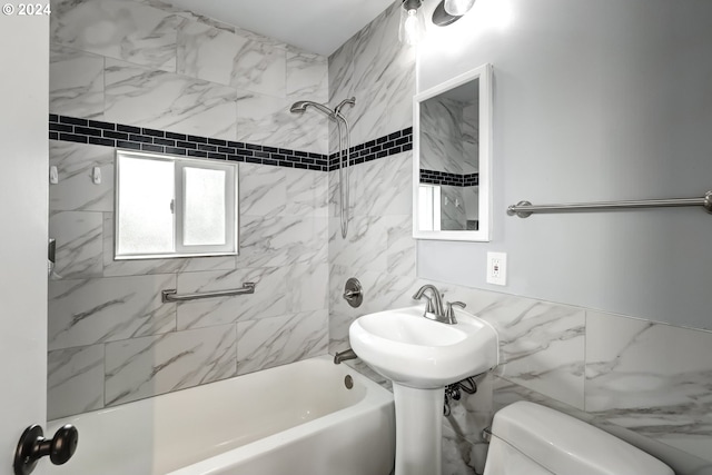 bathroom featuring tile walls, tiled shower / bath combo, and toilet