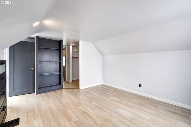 bonus room with light hardwood / wood-style floors and lofted ceiling