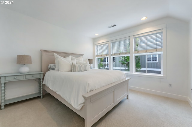 bedroom featuring light carpet and vaulted ceiling