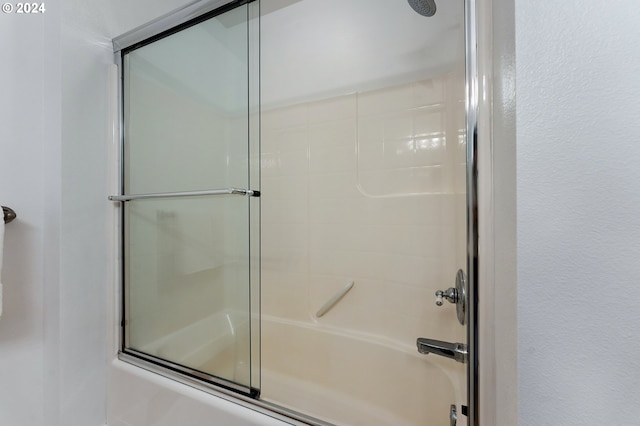 bathroom featuring combined bath / shower with glass door