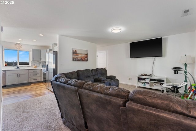 living room featuring light carpet and sink