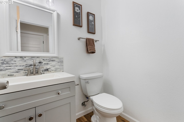 bathroom featuring vanity, backsplash, and toilet