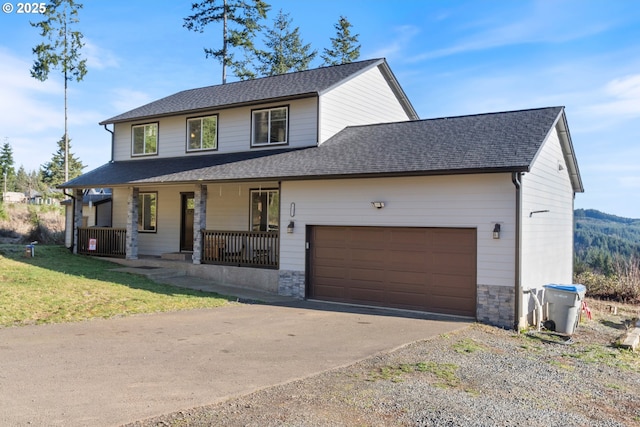 view of front of home with a front yard, a porch, and a garage